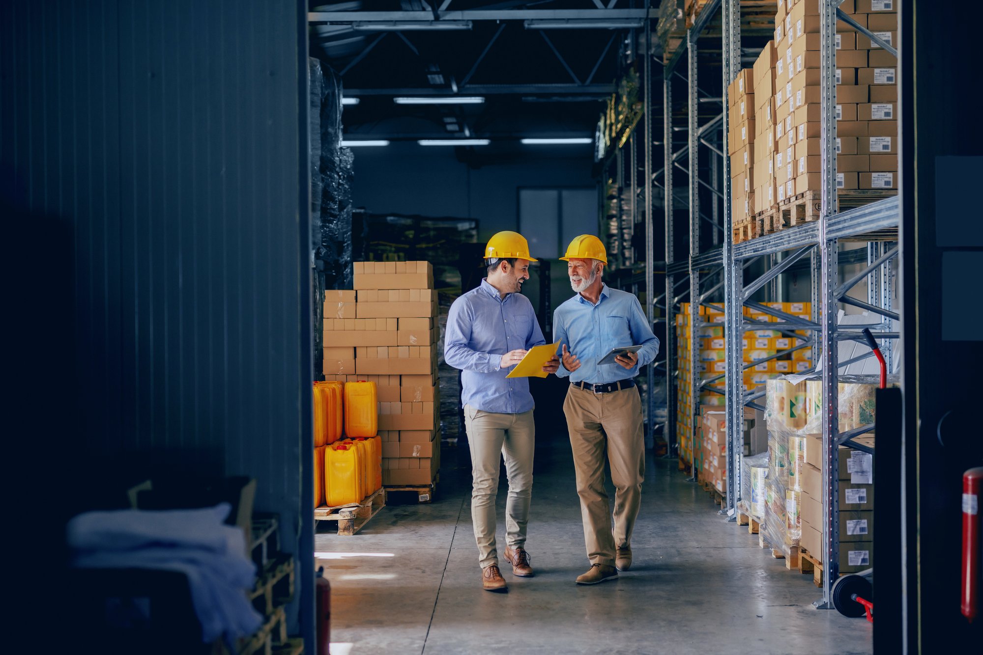 Warehouse workers reviewing inventory records, illustrating inventory management supported by ERP for contract manufacturing